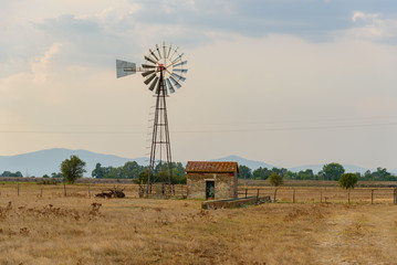 An abandoned shack with a windmill in Albinia, Grosseto, Italy