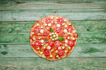 Fototapeta na wymiar Raw pizza on green wood table. Top view