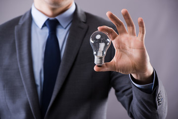 Businessman holding light bulb in creativity concept
