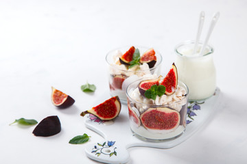 Eton Mess. Fresh figs with whipped cream and meringue in a glass beaker. Dessert.Meringue from egg whites. selective focus