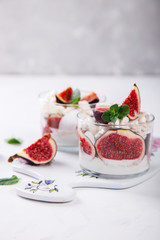 Eton Mess. Fresh figs with whipped cream and meringue in a glass beaker. Dessert.Meringue from egg whites. selective focus