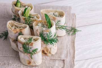 Fototapeta na wymiar Tortilla wraps with cottage cheese, dill and cucumber