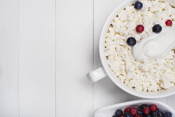 Plate of cottage cheese with sour cream and fresh blueberries