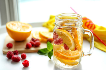Refreshing water with fruits on table