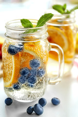 Refreshing water with fruits on table