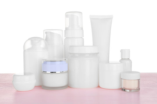 Different cosmetic bottles on table on white background