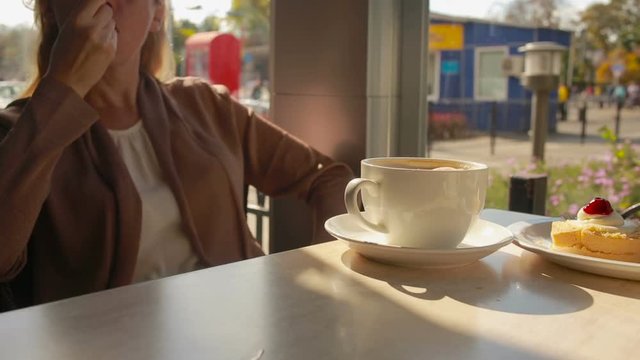 Woman mixing mousse from the coffee and eating it. close up mugs
