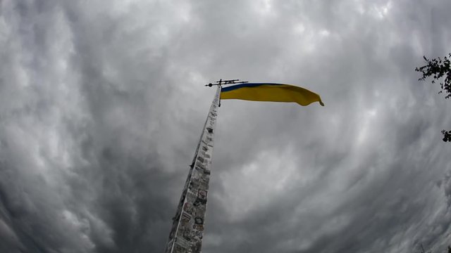 Flag of Ukraine develops on the background of sky.