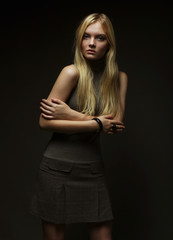 Fototapeta premium Portrait of beautiful young blonde girl in black dress. 