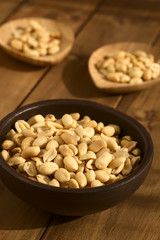 Roasted peeled unsalted peanuts in rustic bowl, photographed with natural light (Selective Focus, Focus one third into the peanuts in the bowl)
