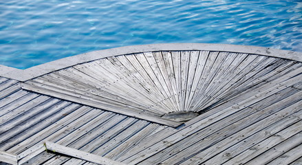 Wooden platform next to infinity pool at tropical resort