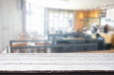 Selected focus empty brown wooden table and Coffee shop blur bac