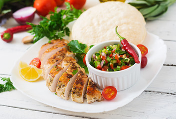Grilled chicken breast with fresh tomato salsa and pita.