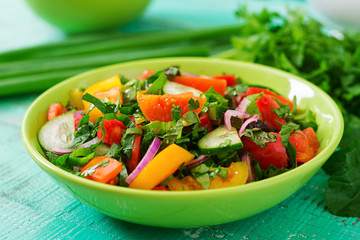 Fresh salad of tomatoes, cucumbers, peppers, arugula and red onion