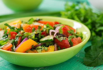 Fresh salad of tomatoes, cucumbers, peppers, arugula and red onion