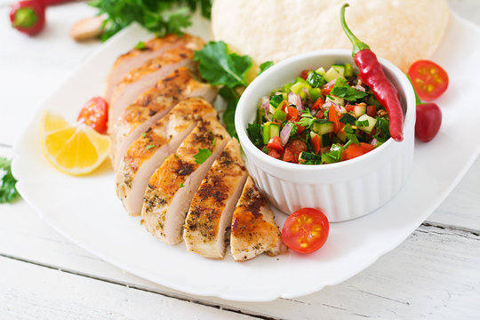 Grilled chicken breast with fresh tomato salsa and pita.