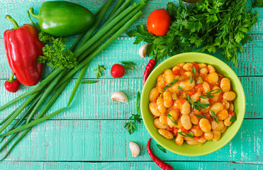 Steamed white beans with vegetables in tomato sauce. Top view