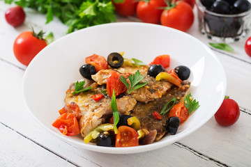 Fried hake fillet with tomato and olives in the Mediterranean style