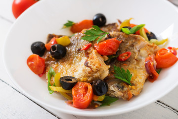 Fried hake fillet with tomato and olives in the Mediterranean style