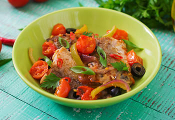 Fried hake fillet with tomato and olives in the Mediterranean style