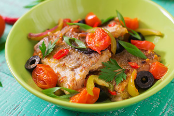 Fried hake fillet with tomato and olives in the Mediterranean style