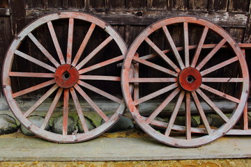Fototapeta na wymiar Wooden wheels leaning onto wooden house
