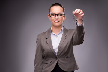 Woman holding keys in housing mortgage concept