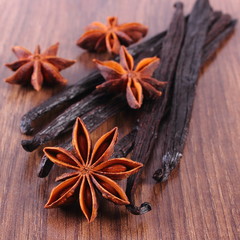 Fragrant vanilla and star anise on wooden surface plank