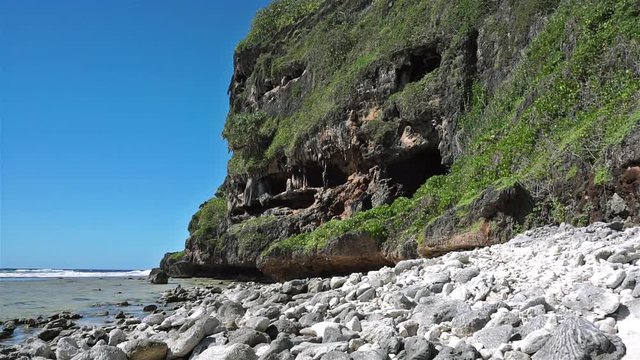 Eroded limestone cliff with cavern on the shore of Rurutu island, Pacific ocean, Austral archipelago, French Polynesia
