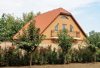 Fototapeta na wymiar Small brick house with red tiled roof