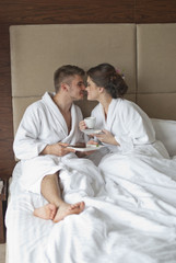 Obraz premium Beautiful young couple having breakfast in bed. 