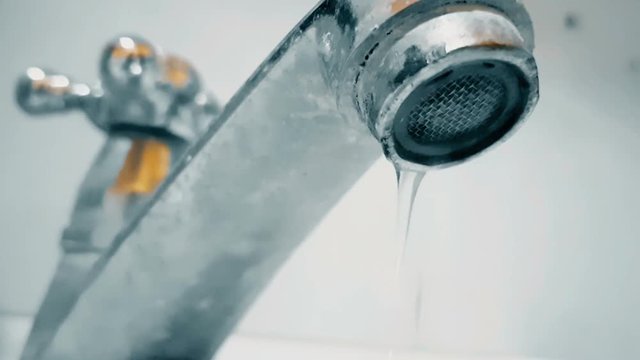 Leaking water tap close-up slow motion