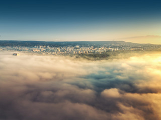 Fototapeta na wymiar Flying above the clouds, view toward the city