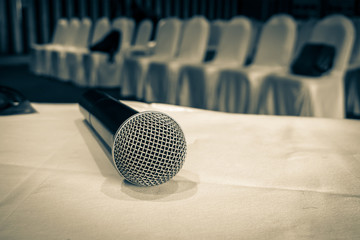 Microphone over the Abstract blurred photo of conference hall or