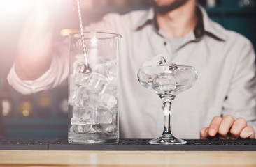 Barman's hands making ice for cocktail