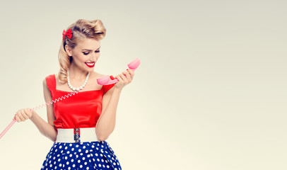 smiling woman with phone, dressed in pin-up style dress