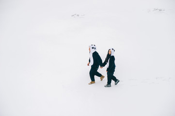 winter love story, a beautiful young couple in suits pandas