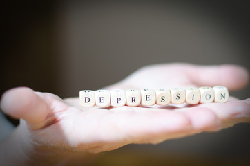 Depression, Buchstabenwürfel auf der Hand, symbolisch