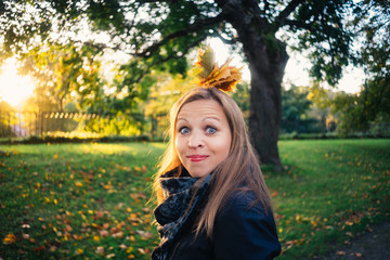Young woman make a grimace in autumnal park