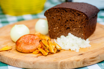 Mushrooms, onions, and bread lying on a round wooden Board.