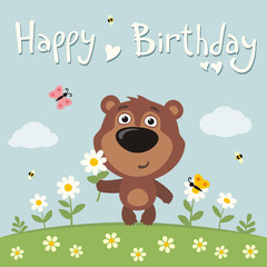 Happy birthday! Cute teddy bear with flower camomile on flower meadow. Birthday card.