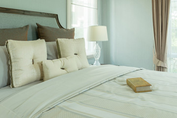 cozy bedroom interior with white pillows and reading lamp on bedside table