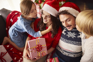 Obraz na płótnie Canvas Kids kissing their parents at Christmas