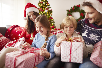 Obraz na płótnie Canvas Kids start opening Christmas presents