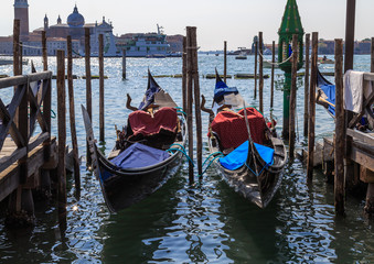 Fototapeta na wymiar Gondolas on the dock on the background San Giorgio Maggiore Island