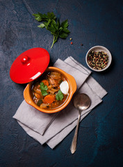 Homemade meat and vegetable stew in a bowl, top view