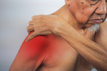 Naklejka premium senior man hand holding healthy arm and massaging he shoulder in