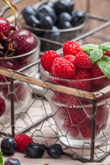 small glasses of fruit containing cherry, blueberry and rasberry