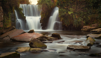 Herbstfarben erscheinen rund um die Wasserfälle in Penllergare Woods, Swansea, UK