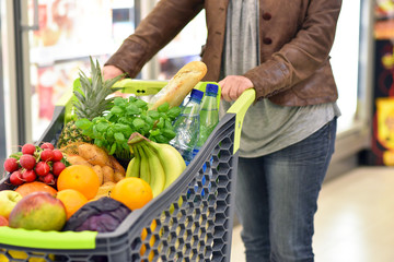 gesunde Ernährung: Einkaufswagen im Supermarkt mit frischem Obst und Gemüse // shopping cart in...